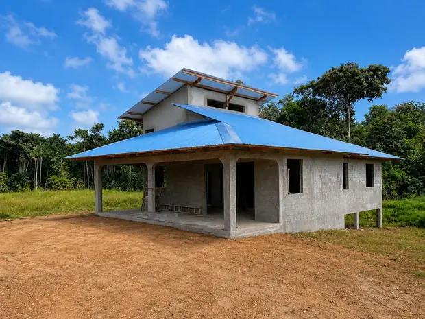 Maison avec toiture tôle bleue et carbet en Guyane
